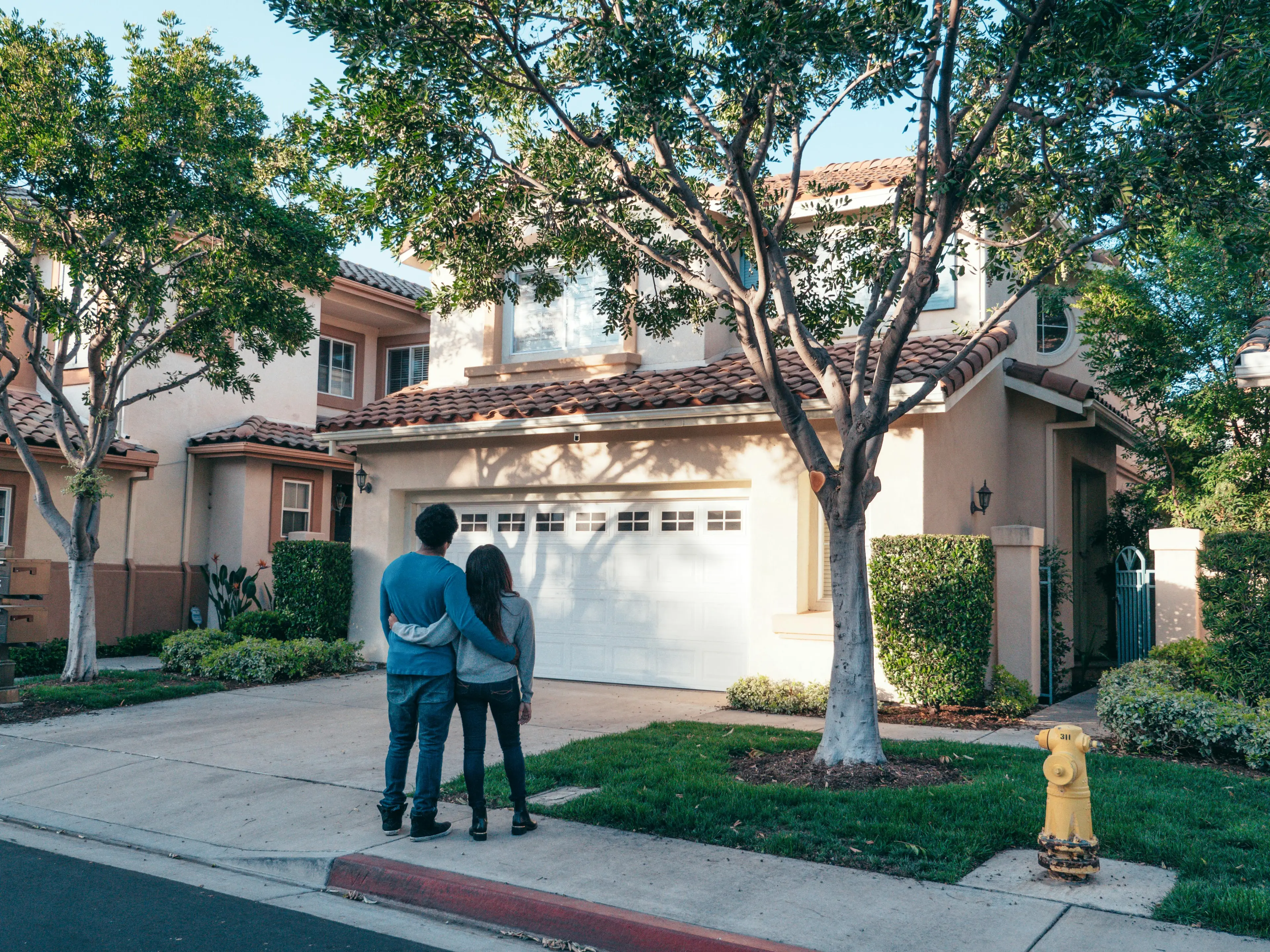 REELIST8 Real Estate couple in front of home